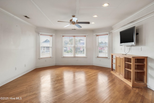 unfurnished living room featuring baseboards, visible vents, ceiling fan, wood finished floors, and crown molding