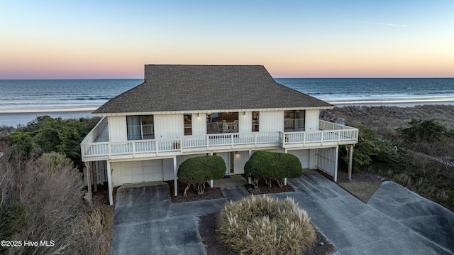 view of front of home featuring a water view, a garage, and a beach view