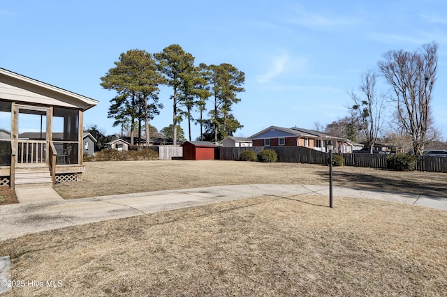 view of yard with a storage shed and a sunroom