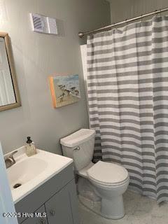 full bathroom featuring curtained shower, vanity, and toilet