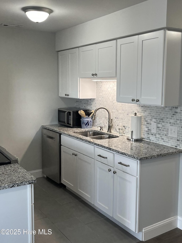 1801 Canal Dr Unit D14, Carolina Beach, NC 28428 - kitchen featuring black microwave, a sink, white cabinetry, and backsplash
