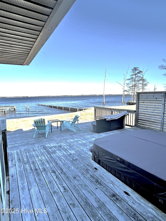 deck featuring a water view and a covered hot tub