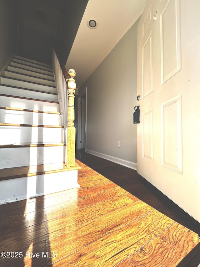 stairway featuring lofted ceiling and wood-type flooring