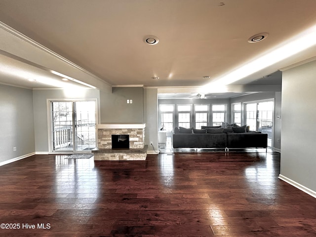 unfurnished living room with crown molding, dark hardwood / wood-style flooring, ceiling fan, and a fireplace