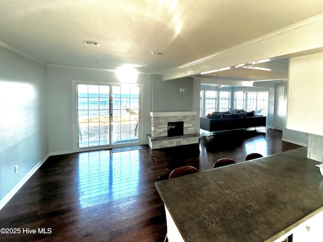 living room featuring crown molding, dark hardwood / wood-style floors, a textured ceiling, and a fireplace