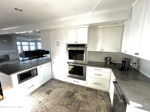 kitchen featuring tasteful backsplash, ornamental molding, white cabinets, and appliances with stainless steel finishes