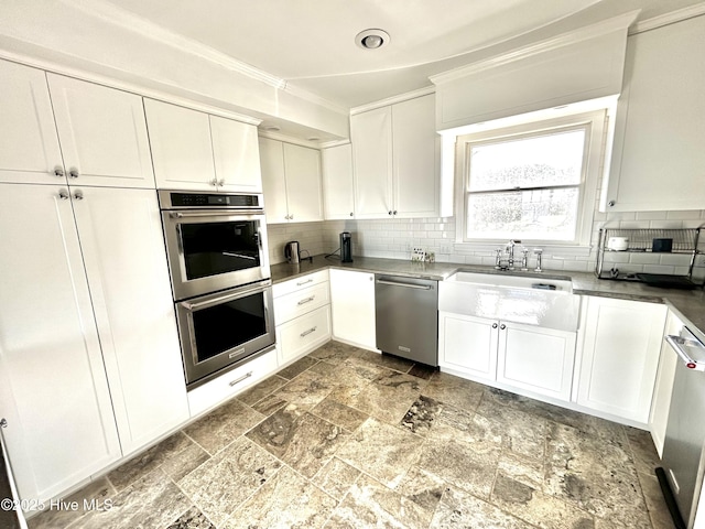 kitchen with white cabinetry, sink, tasteful backsplash, and stainless steel appliances