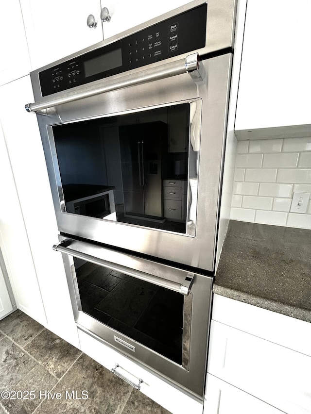 details with white cabinetry and backsplash