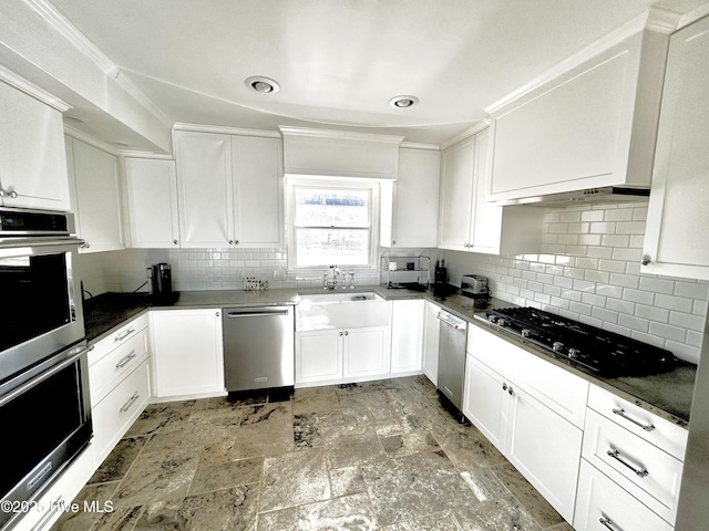 kitchen with stainless steel appliances, sink, white cabinets, and decorative backsplash