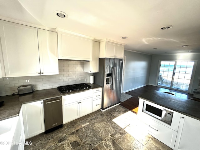 kitchen with tasteful backsplash, appliances with stainless steel finishes, and white cabinets