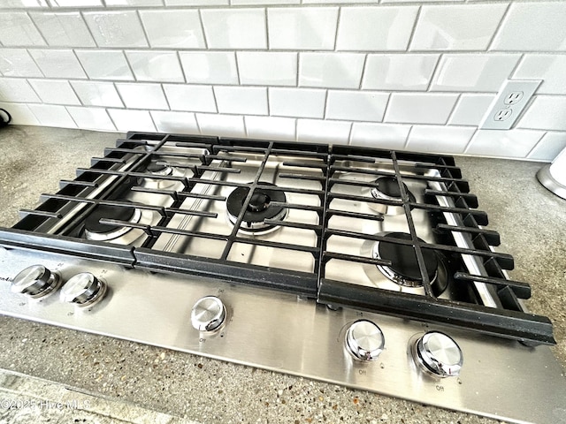 room details with stainless steel gas stovetop and backsplash