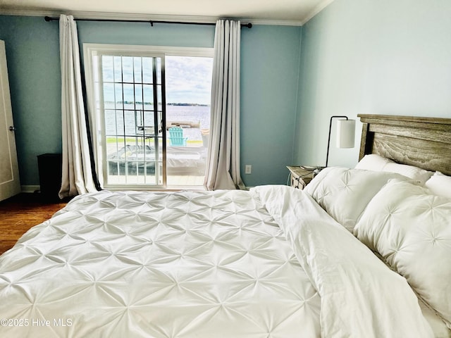 bedroom with ornamental molding, a water view, dark wood-type flooring, and access to outside