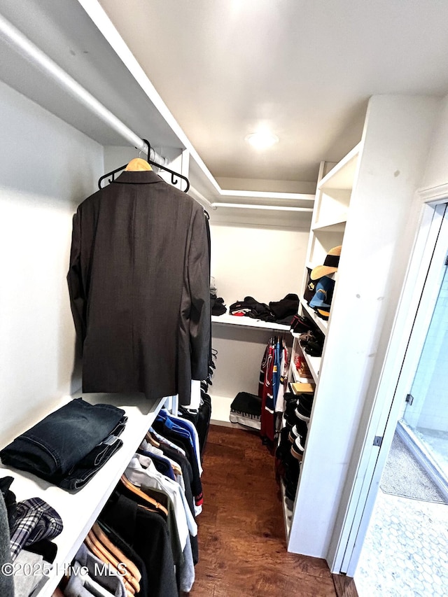 walk in closet with dark wood-type flooring