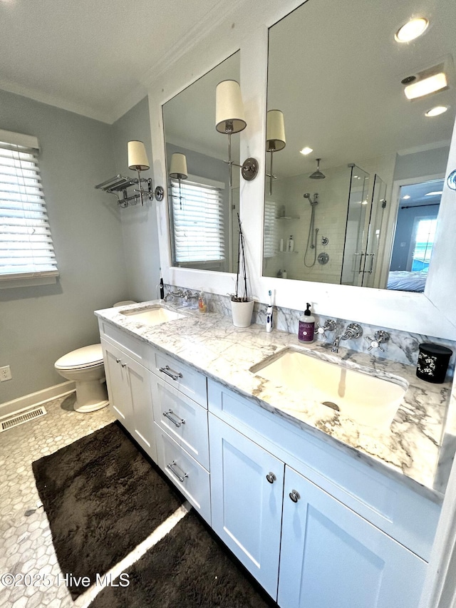 bathroom with ornamental molding, toilet, vanity, and walk in shower