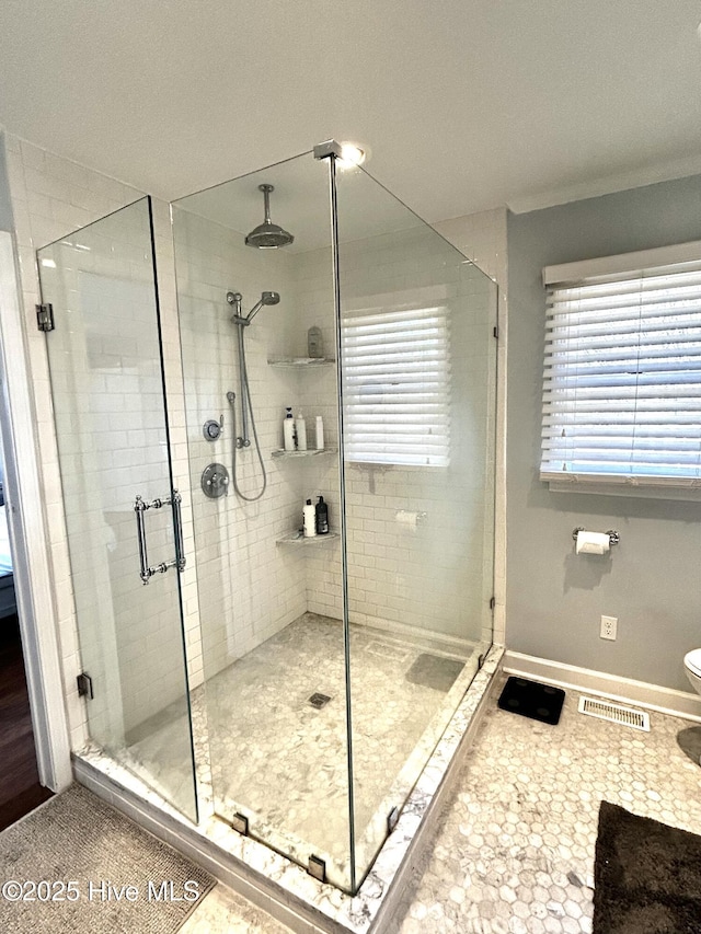 bathroom with tile patterned floors, toilet, and a shower with shower door