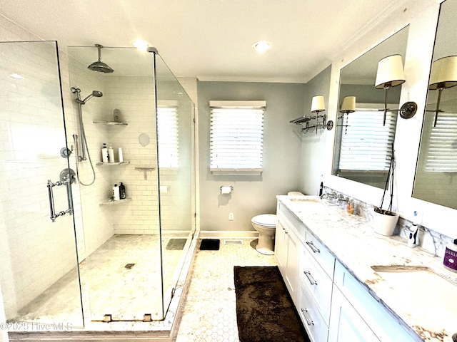 bathroom with ornamental molding, toilet, a shower with shower door, and vanity