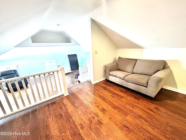 interior space featuring radiator heating unit, wood-type flooring, and vaulted ceiling