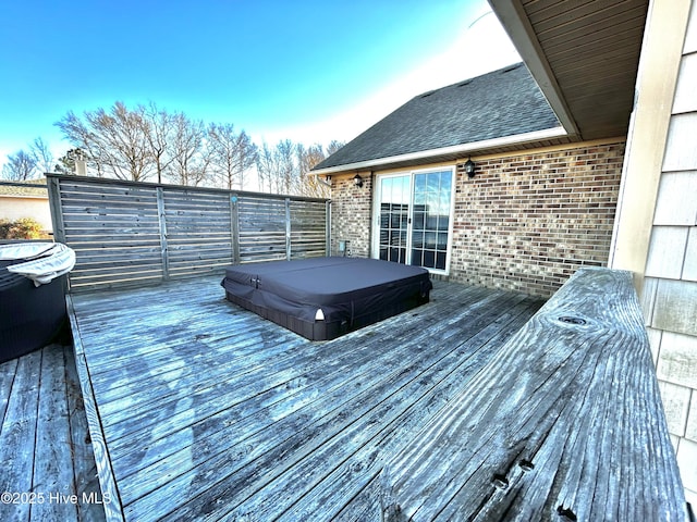 wooden deck with a covered hot tub