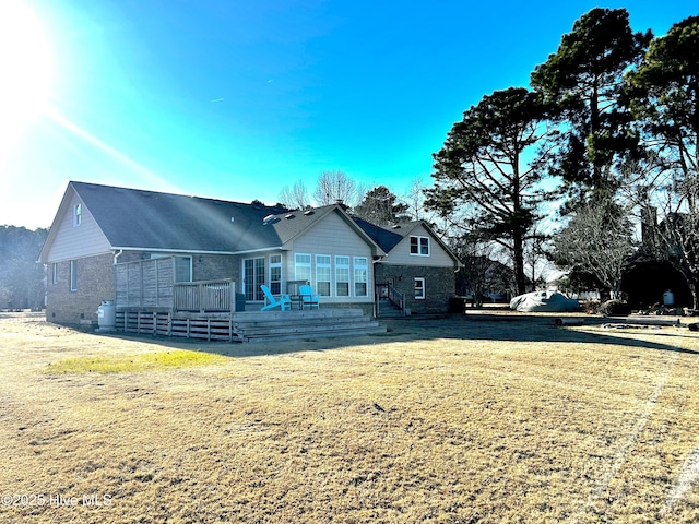 rear view of house with a wooden deck and a yard