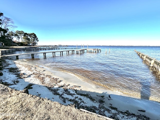 view of dock featuring a water view and a view of the beach