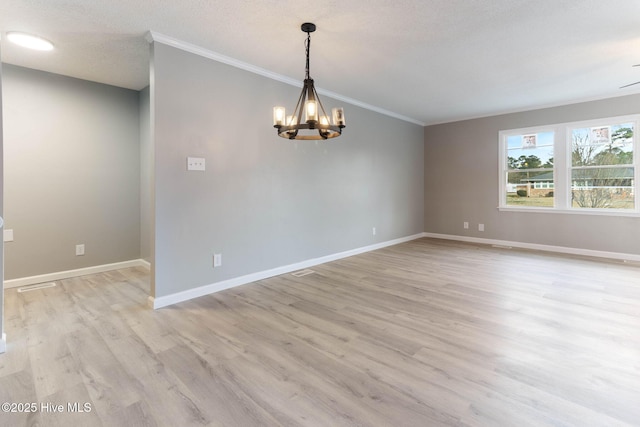 unfurnished room featuring ornamental molding, a chandelier, a textured ceiling, and light wood-type flooring