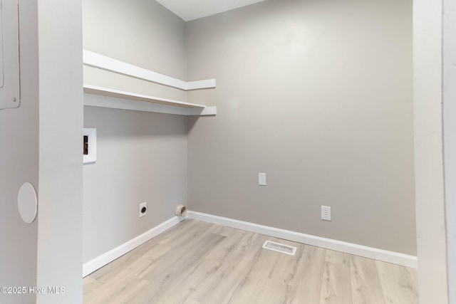 clothes washing area with hookup for a washing machine, hookup for an electric dryer, and light wood-type flooring