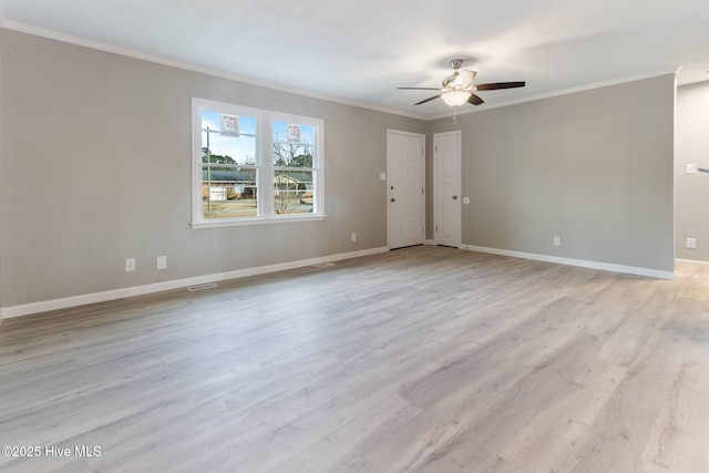 empty room with ornamental molding and light hardwood / wood-style floors