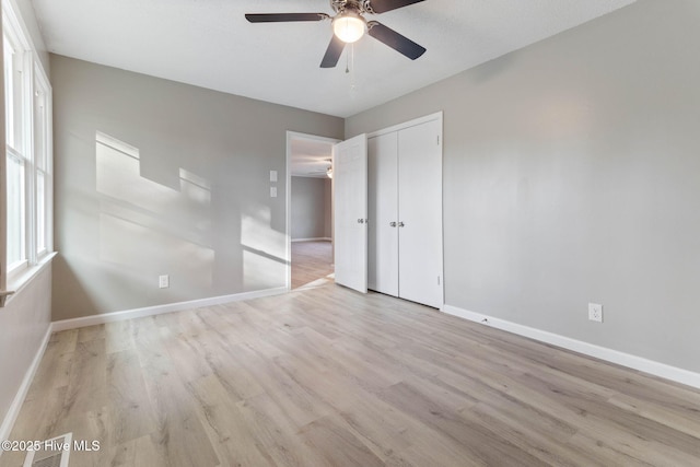 unfurnished bedroom with a closet, ceiling fan, and light wood-type flooring