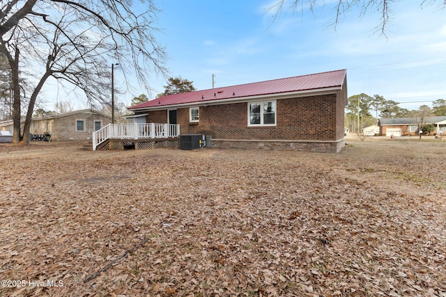 rear view of house with central AC and a deck