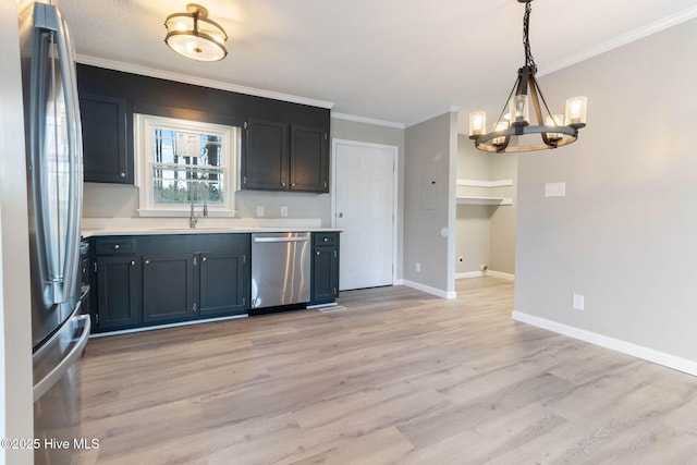 kitchen featuring stainless steel appliances, ornamental molding, sink, and decorative light fixtures