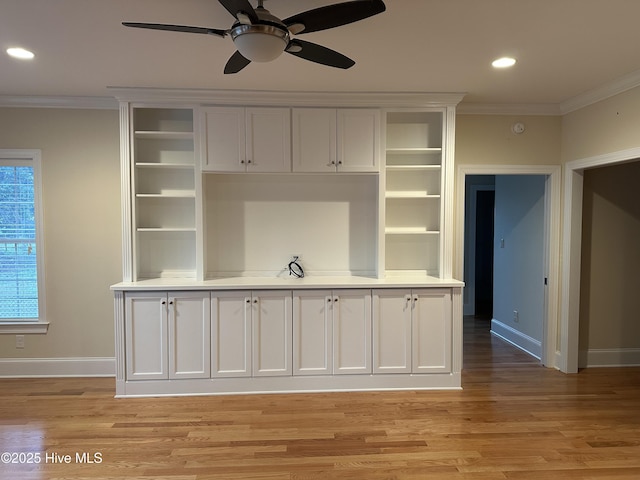 interior space with crown molding, baseboards, and light wood-type flooring