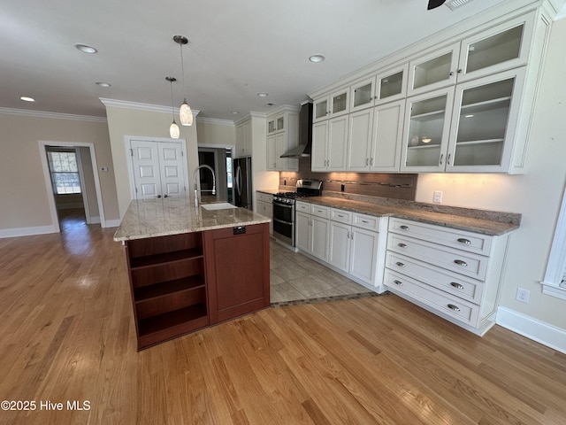 kitchen with open shelves, a sink, freestanding refrigerator, wall chimney range hood, and range with two ovens