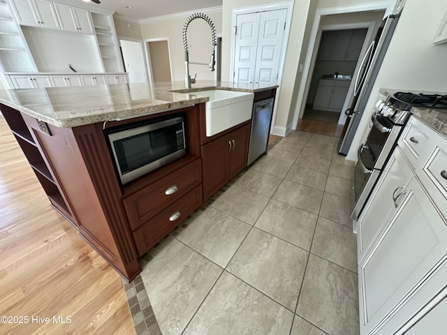 kitchen with open shelves, a sink, ornamental molding, stainless steel appliances, and white cabinets