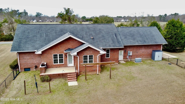 back of house with a lawn, fence private yard, and brick siding