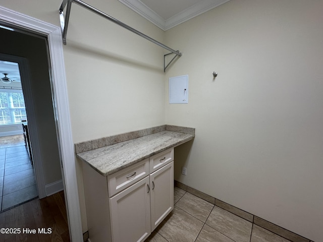 laundry area with light tile patterned floors and crown molding