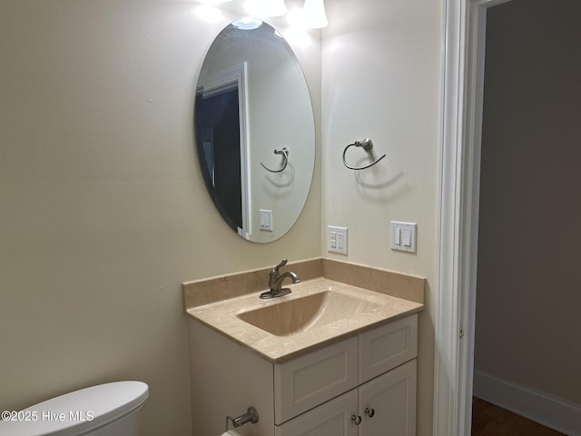 half bathroom featuring vanity and toilet