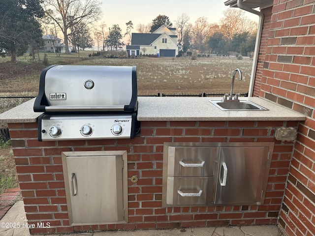 view of patio with an outdoor kitchen, area for grilling, and a sink