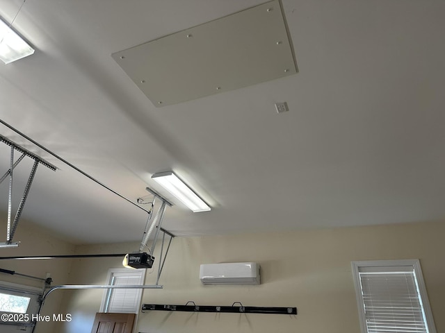 interior details featuring a garage door opener and a wall unit AC