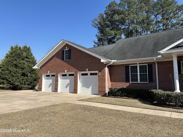 view of front facade with brick siding, roof with shingles, and driveway