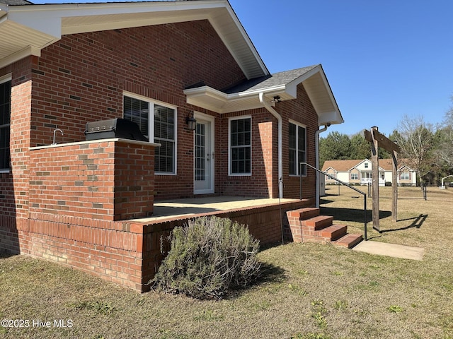 view of home's exterior featuring a yard and brick siding