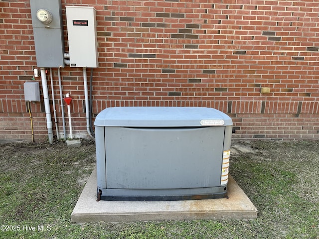 details featuring brick siding, electric meter, and a power unit