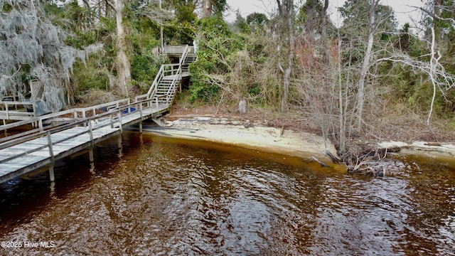 view of dock featuring a water view and stairs