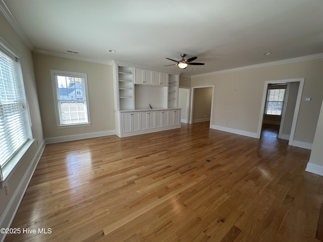 unfurnished living room featuring baseboards, crown molding, and light wood finished floors