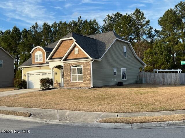 view of front of house with a garage, a front yard, and central air condition unit