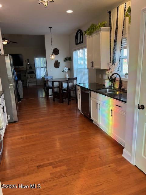 kitchen with sink, white cabinetry, stainless steel refrigerator, dishwasher, and light hardwood / wood-style floors