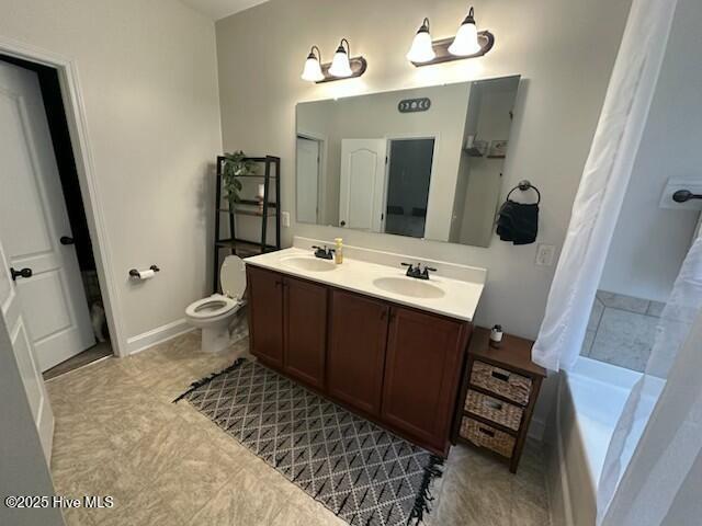 bathroom featuring vanity, a washtub, and toilet