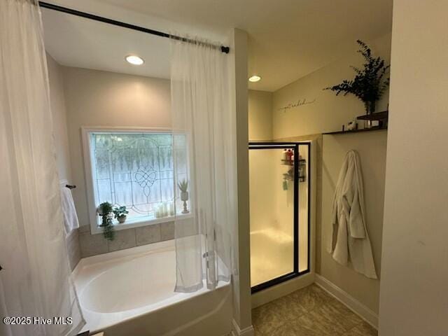 bathroom featuring shower with separate bathtub