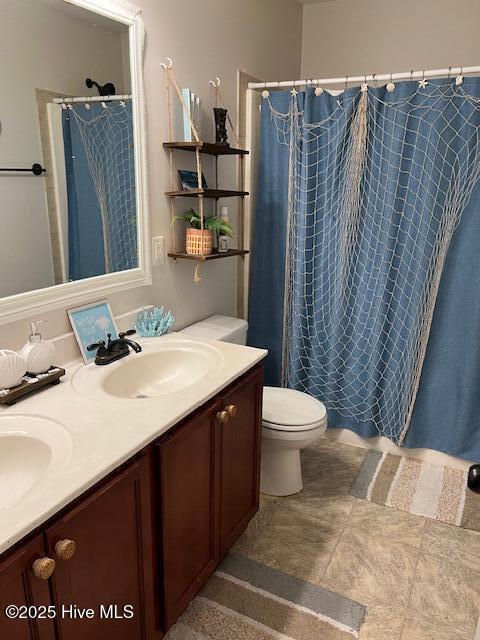 bathroom featuring vanity, walk in shower, and toilet