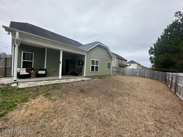 back of house with a patio and a yard