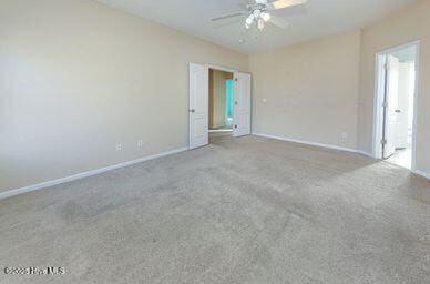 spare room featuring light carpet and ceiling fan